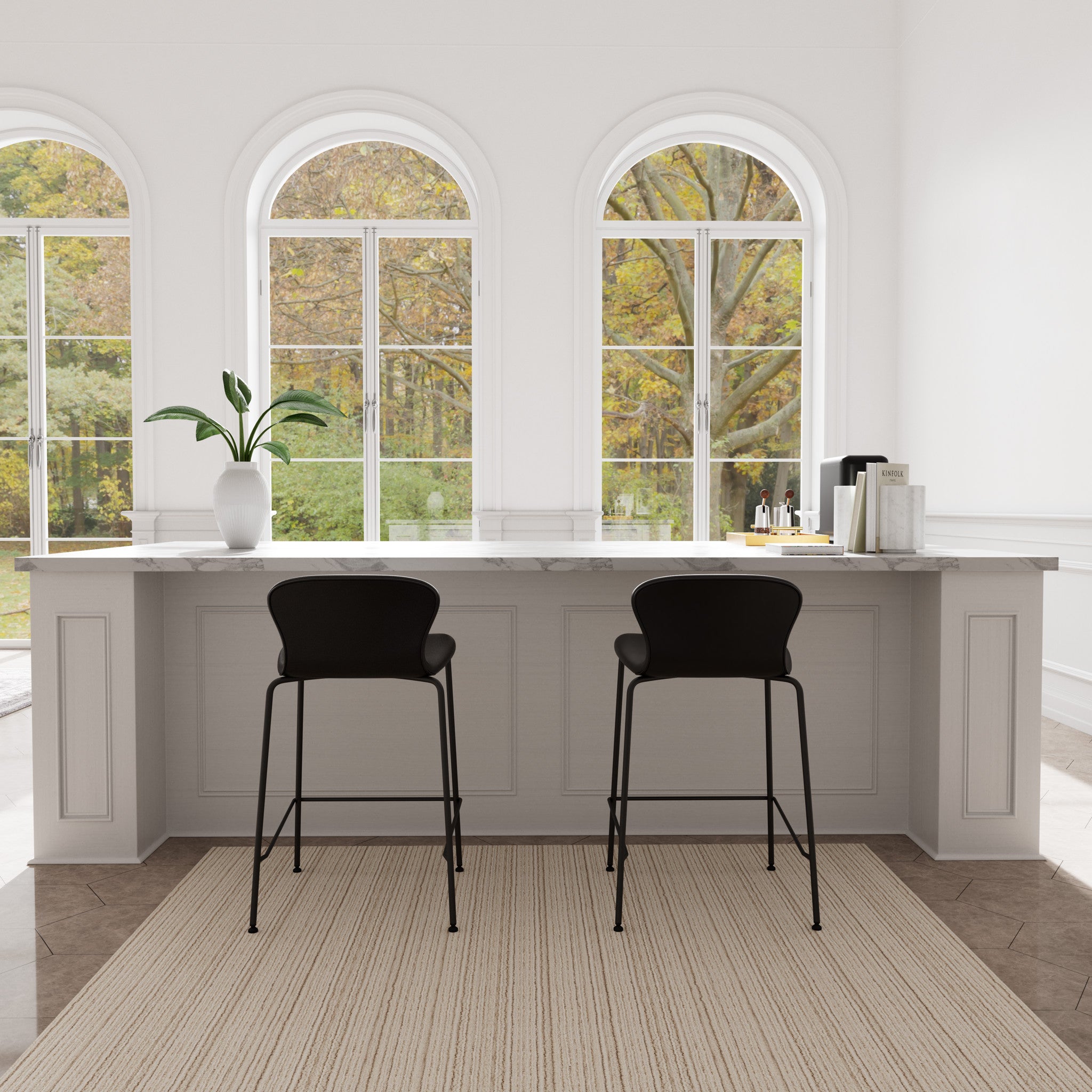 Modern kitchen with white island, black counter stools, and large windows.